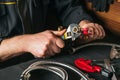 Plumber screws brass fitting into the valve with a plumbing wrench. Hands of the master closeup in a workshop