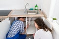 Plumber Showing Damage In Sink Pipe To Woman Royalty Free Stock Photo