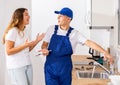 Plumber shows the landlady of the apartment the completed work on repairing the faucet