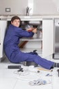 Plumber sitting on the floor repair a pipe Royalty Free Stock Photo