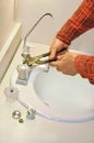 Plumber tightens leaky faucet Royalty Free Stock Photo