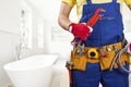 Plumber with tool belt standing in bathroom Royalty Free Stock Photo