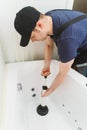 Plumber unclogging bathtub