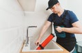 Plumber unclogging kitchen sink