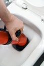 Plumber unclogging toilet Royalty Free Stock Photo