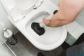 Plumber unclogging toilet