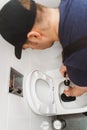 Plumber unclogging toilet Royalty Free Stock Photo