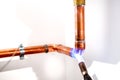 Plumber using blowtorch, propane gas torch for welding copper pipes
