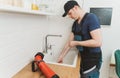 Plumber using drain snake