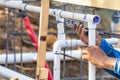Plumber Using Level While Installing PVC Pipe At Construction Site Royalty Free Stock Photo