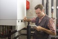 Plumber who carries out the maintenance of a condensing boiler Royalty Free Stock Photo