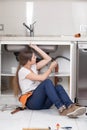 Plumber woman repairing de pipe of the kitchen Royalty Free Stock Photo
