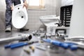 Plumber at work in a bathroom, plumbing repair service, assemble Royalty Free Stock Photo