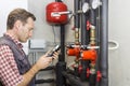 Plumber at work measures the temperature in a boiler room Royalty Free Stock Photo