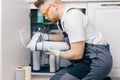 Plumber working change cartridge filter for water in white kitchen. Concept filtration system Royalty Free Stock Photo