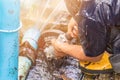 Plumber working repair the broken pipe and replace in hole with water Motion at roadside