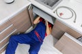 plumber working under domestic kitchen sink Royalty Free Stock Photo