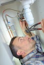 Plumber working under kitchen sink Royalty Free Stock Photo