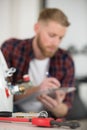 plumber writing in clipboard and checking electric boiler