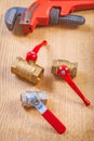 Plumbers fixtures and monkey wrench on wooden board Royalty Free Stock Photo