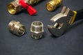 Plumbing brass fittings and adjustable spanner close up on dark background during repair or replacement of spare parts