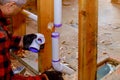 Plumbing building contractor installing plastic drain pipe in the floor section for custom house