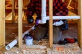 Plumbing contractor installing plastic PVC pipe in under the bathroom sink