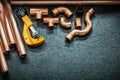 Plumbing concept copper pipes pipe cutter and fittings on black background Royalty Free Stock Photo