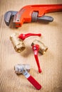 Plumbing fixtures and monkey wrench on wooden board Royalty Free Stock Photo