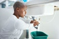Plumbing, leak and time with a black woman in the bathroom of her home waiting for repair assistance. Sink, emergency Royalty Free Stock Photo