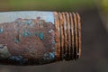 Plumbing old rusty water pipe with remnants of sealant and tow on worn threads, peeling paint, selective shallow depth of field Royalty Free Stock Photo