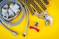 Plumbing tools and gloves for connecting water hoses on yellow background Royalty Free Stock Photo