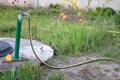 Plumbing, water pump from a well. An outside water faucet with a yellow garden hose attached to it. Irrigation water pumping Royalty Free Stock Photo