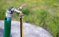 Plumbing, water pump from a well. An outside water faucet with a yellow garden hose attached to it. Irrigation water pumping Royalty Free Stock Photo