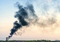 Plume of smoke from a fire above city at sunset Royalty Free Stock Photo