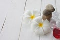 Plumeria and Gel bottle is placed on a white wooden floor