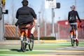 Plump guy and slender girl ride rented social bicycles in city rental station