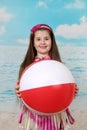 Plump little girl on beach with big ball in hands