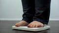 Plump male checking body weight on scales, health disorder, overeating result Royalty Free Stock Photo