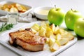 plump pork chops with apple sauce and sliced apples on a marble surface Royalty Free Stock Photo