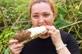 Plump Woman Chewing A Cassava Root