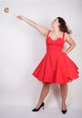 Plump woman in a red pinup dress. chubby fashionable girl standing on white background in Studio Royalty Free Stock Photo