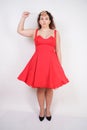 Plump woman in a red pinup dress. chubby fashionable girl standing on white background in Studio Royalty Free Stock Photo