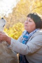 A plump woman with a white Labrador dog walking in a Park or forest on a Sunny autumn day Royalty Free Stock Photo