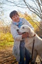 A plump woman with a white Labrador dog walking in a Park or forest on a Sunny autumn day Royalty Free Stock Photo