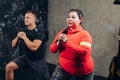 Plump woman with a sporty man doing exercises in the sport center Royalty Free Stock Photo