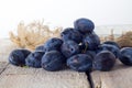 Plums. Blue and violet plums on wooden table..