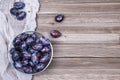 Plums in a bowl on wooden background. Top view. Royalty Free Stock Photo