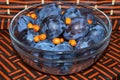 Plums in a glass bowl sprinkled with sea buck-thorn