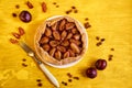 Plums pie with raisins on a white plate on yellow wooden background decorated with three fresh plums, brown raisins Royalty Free Stock Photo